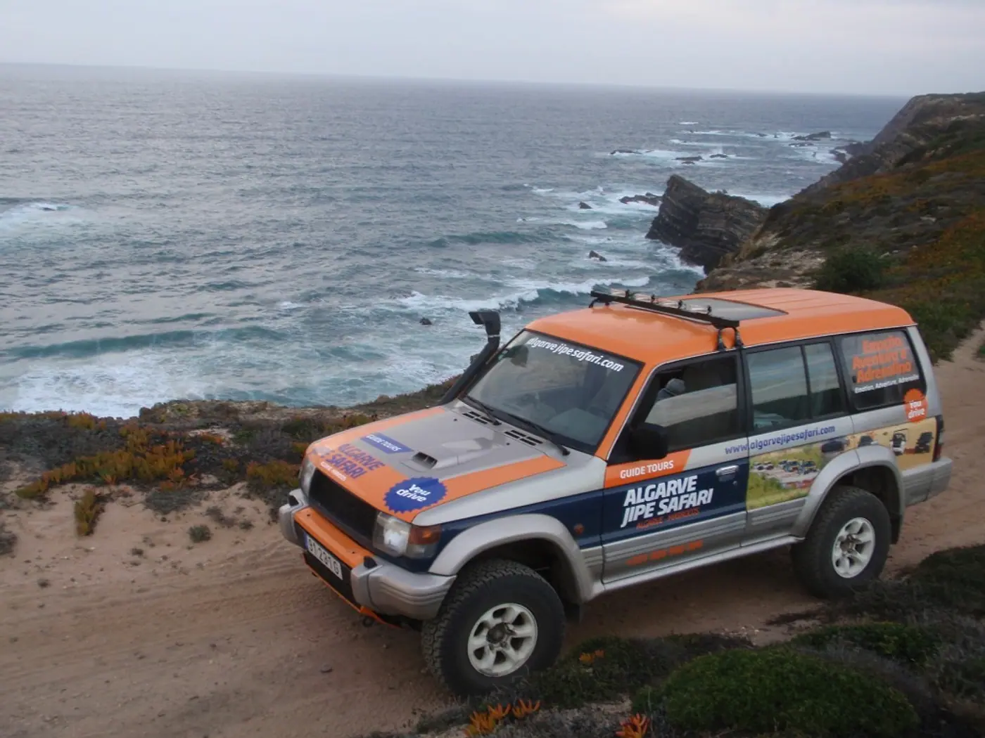 Orange jeep on a coastal trail